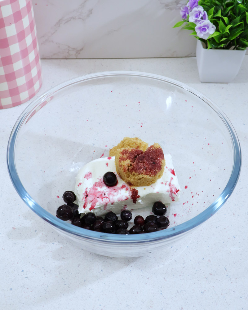 Glass bowl with softened cream cheese, brown sugar and blueberrries
