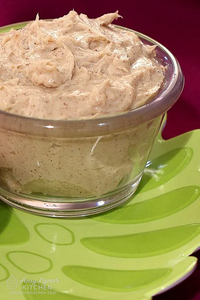 Close-up of whipped brown sugar cinnamon cream cheese in a glass bowl on a green plate
