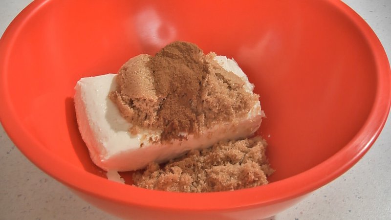 Medium mixing bowl with cream cheese, brown sugar and cinnamon added.