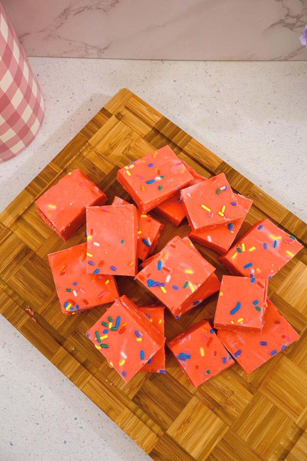 Overhead view of Cherry Kool-Aid fudge squares topped with colorful sprinkles