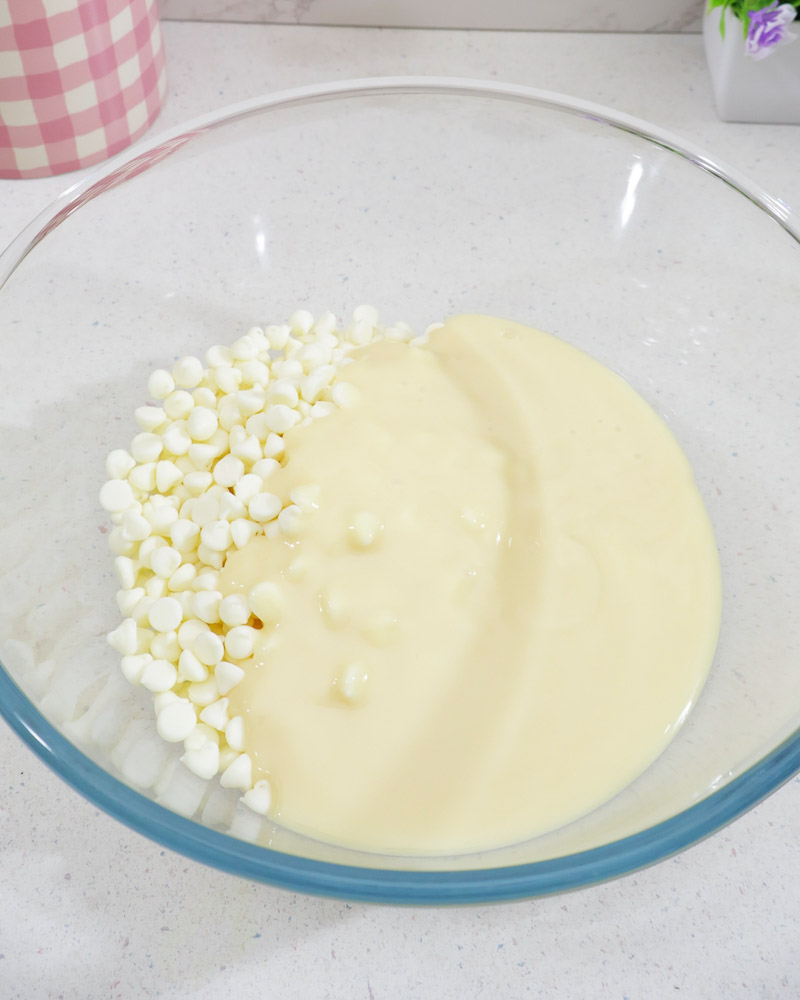 Glass bowl with white chocolate morsels and sweetened condensed milk