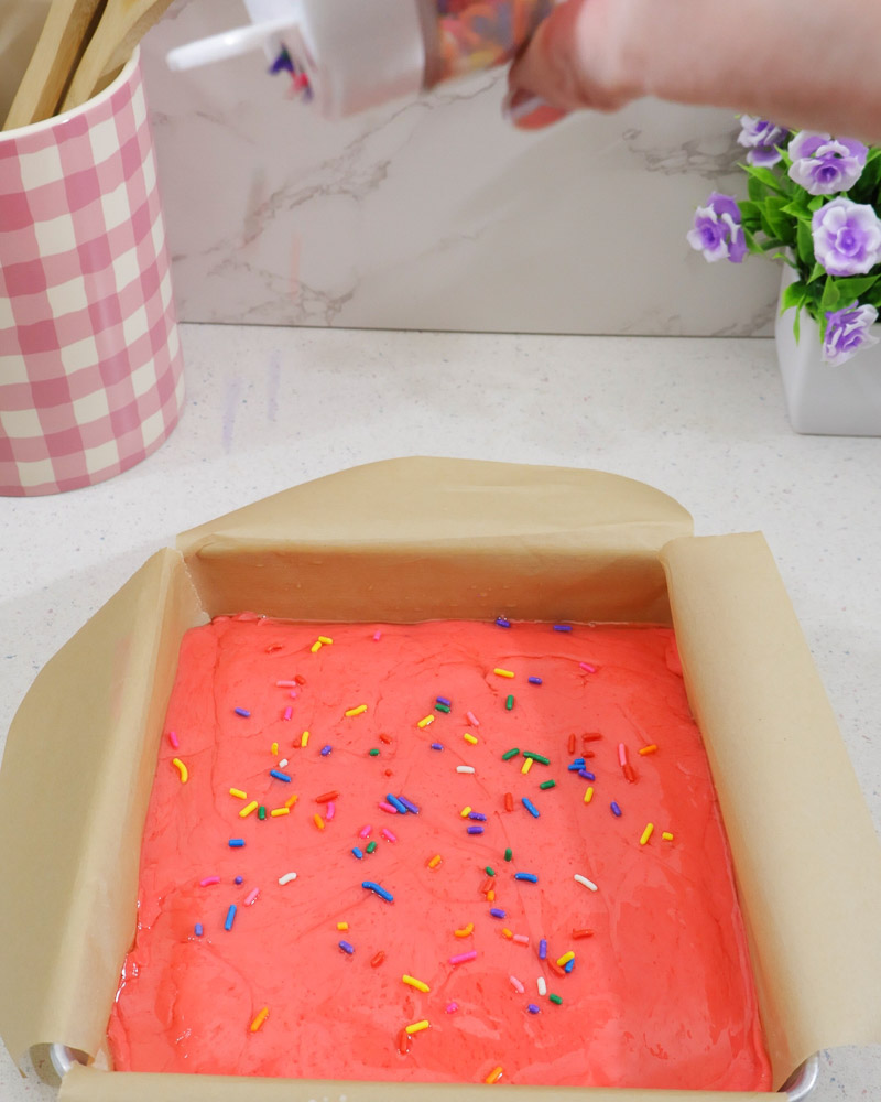 Colorful sprinkles added to the top of the fudge