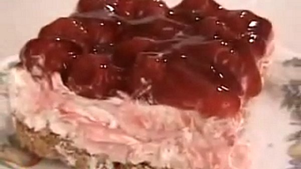 Slice of Cherry Delight layered with fluffy cream cheese filling, sweet cherry topping, and buttery graham cracker crust - an easy no-bake dessert perfect for summer gatherings.