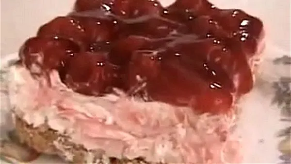 Slice of cherry delight topped with cherry pie filling.