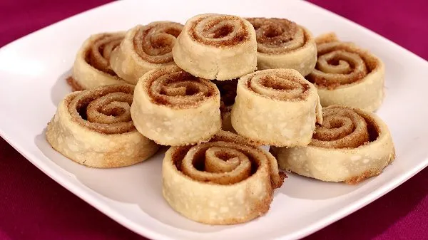 Cinnamon sugar pinwheels stacked on a white plate.
