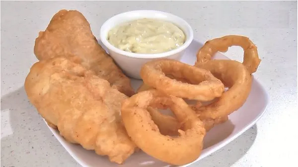 A plate of fish and onion rings coated in a delicious batter.