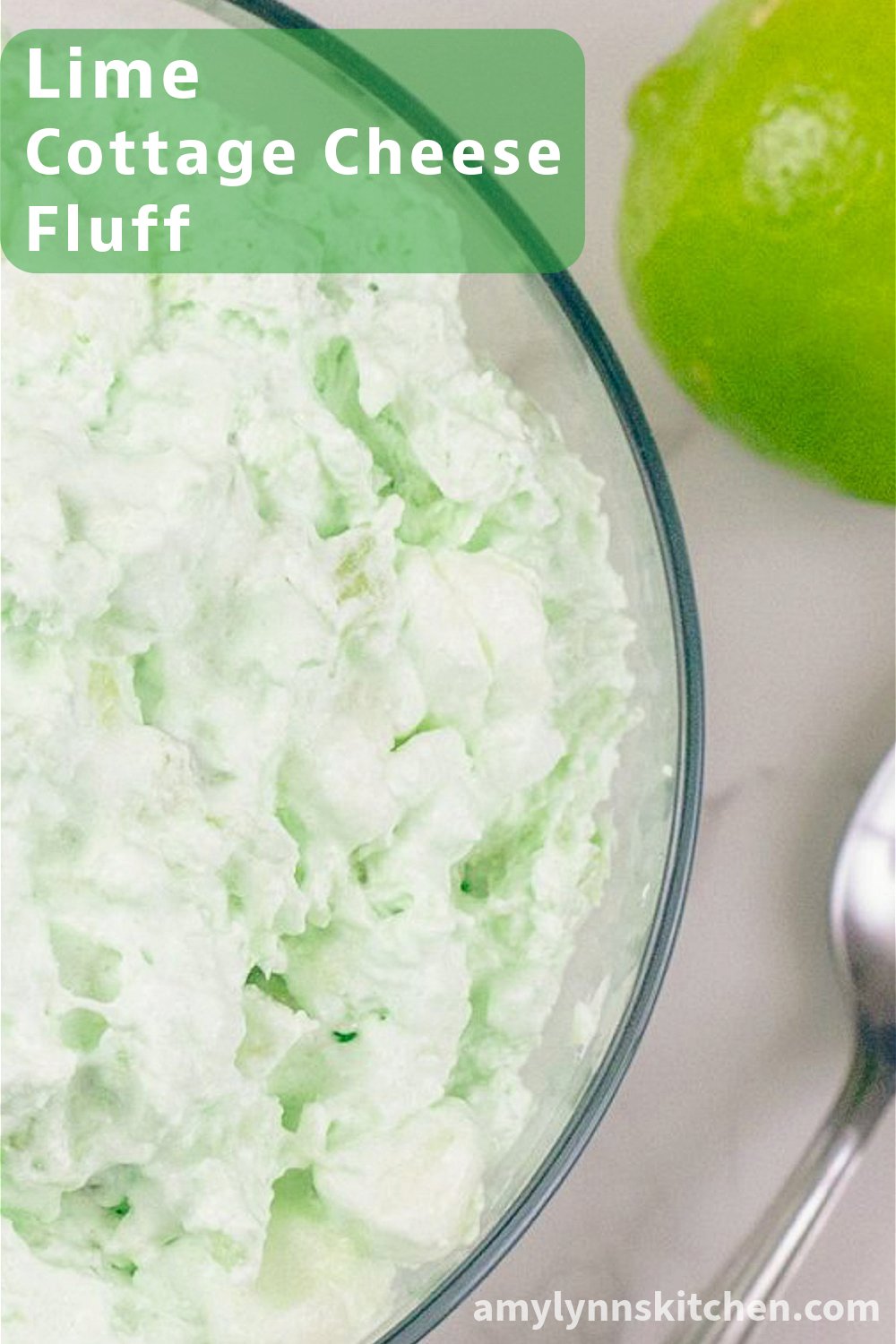 Overhead view of lime cottage cheese fluff in a glass bowl - pastel green retro dessert with pineapple, mini marshmallows, and whipped topping