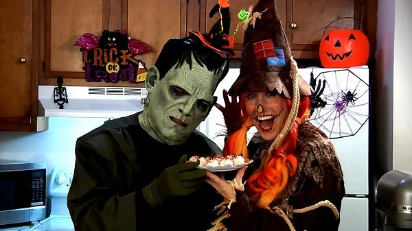 Amy dressed as a scarecrow and sidekick Frankie holding a plate of no bake halloween pumpkin cheesecake balls.