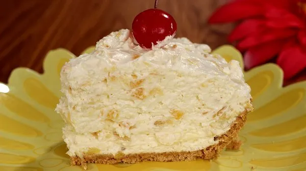 Slice of creamy pineapple pie topped with a cherry