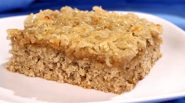 A big slice of oatmeal cake on a white plate.
