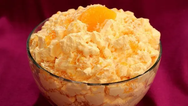 Bowl of orange fluff topped with a mandarin orange.