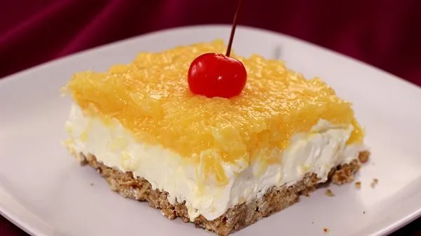 No-bake pineapple pretzel dessert with creamy filling, salty-sweet crust, and cherry topping-perfect for summer parties.