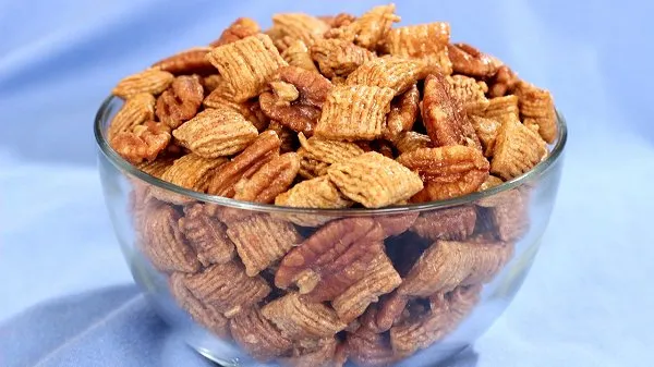 Praline pecan crunch nearly overflowing in a clear bowl.
