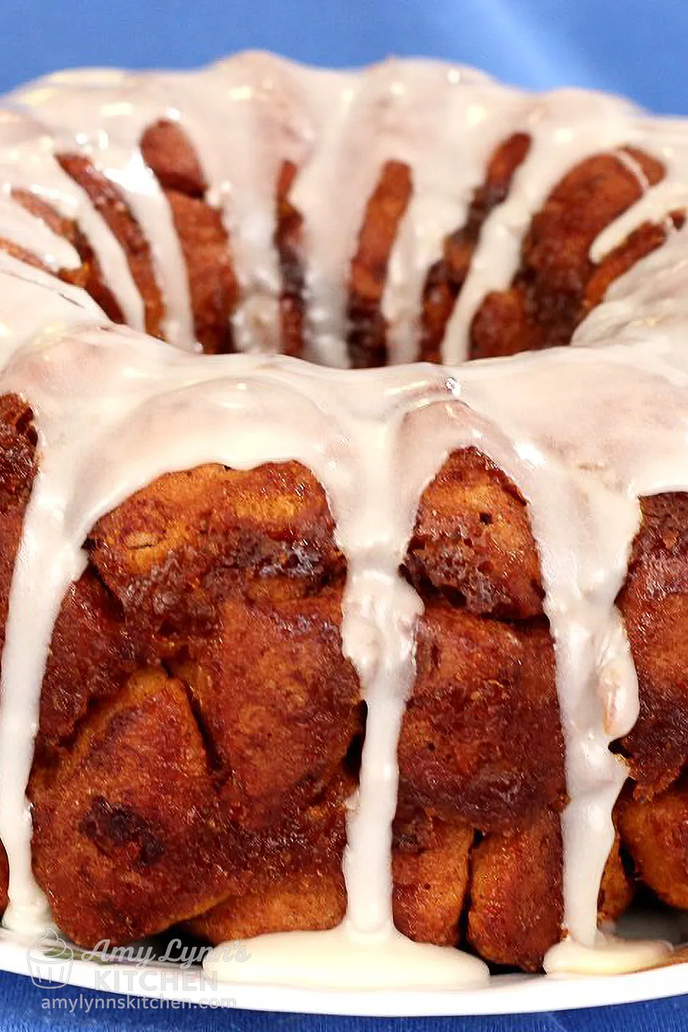 Close-up of Pumpkin Cinnamon Roll Monkey Bread drizzled with icing, showing the soft pull-apart texture and golden cinnamon pieces.