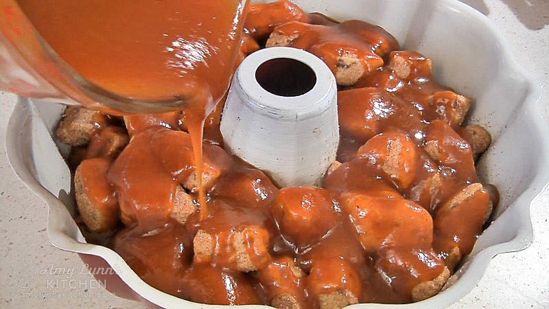 Pour the melted pumpkin sauce evenly over the top of the cinnamon roll pieces in the pan.