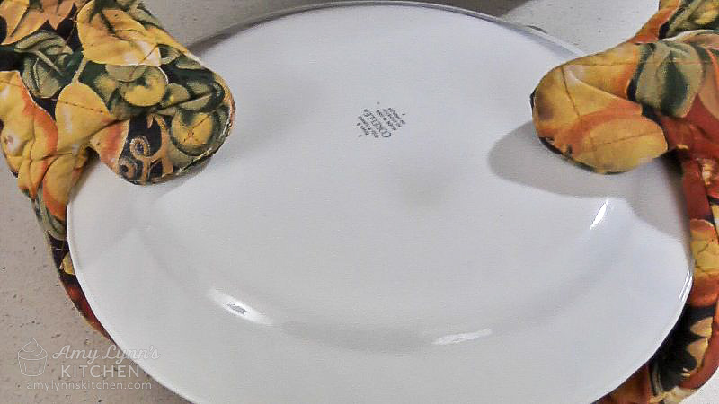 Place a serving plate or platter over the pan.