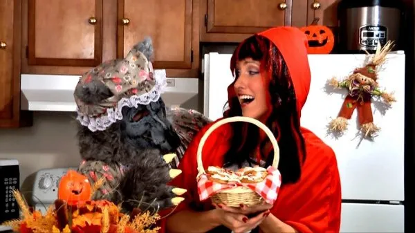 Amy Lynn dressed as Little Red Riding Hood holding a basket of pumpkin cookies, with Frankie as the Big Bad Wolf reaching for the basket.