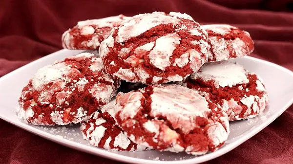 Vibrant red velvet Valentine cookies stacked on a white plate.