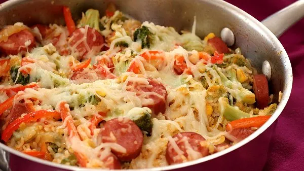 Skillet full of flavorful sausage, broccoli and rice topped with melted mozzarella cheese.